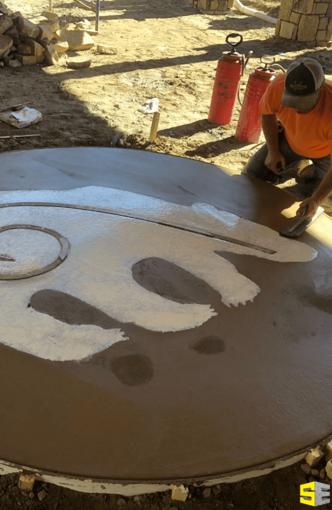 A person working on the concrete image of a bear