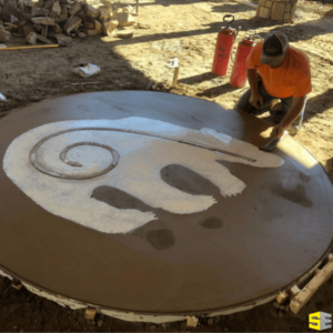 Person working on a concrete artistic image of a bear.