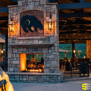 An image focusing on the fireplace as the centerpiece for outdoor lighting