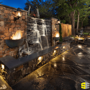 A water feature with built in lights on either side of it as well as lights built into the base