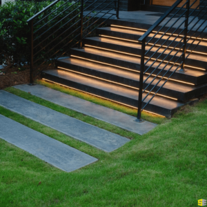 A finished concrete walkway leading up to front stairs with lighting underneath them