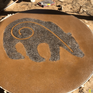 A 2D concrete carving of a bear, drying in the sun