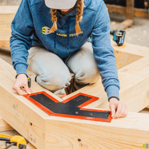 A Straight Edge worker, using an outline to measure a frame