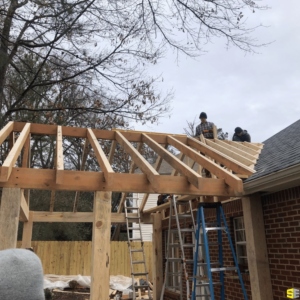 The frame being built by construction workers of an outdoor patio area