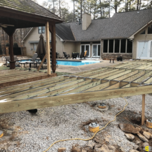 The frame for an extension of an outdoor patio outside a residential home