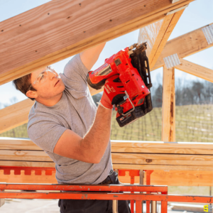 A construction worker stapling together frame pieces