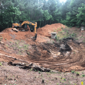 A construction site of a crane digging a hole to accommodate a drainage area