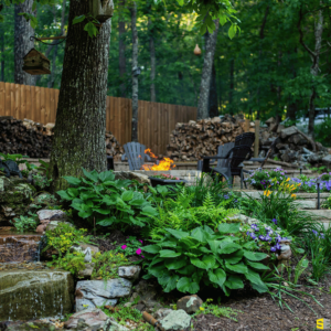 A beautifully landscaped backyard with a fire pit in the background