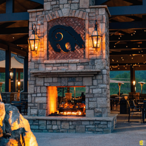 A close up of a fireplace with a bear carved concrete image on the hearth