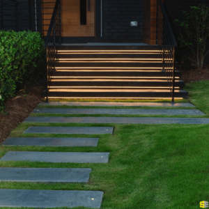 A concrete walkway leading to the illuminated concrete steps