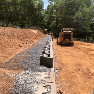 Two workers, moving stones to create a retaining wall