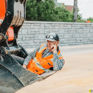 A worker, deep in thought, sitting in the bucket of a crane